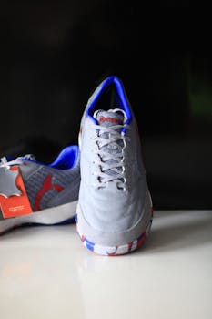 Close-up of a trendy grey athletic shoe with blue and red accents.