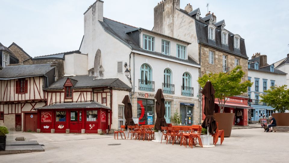 Picturesque view of a historic square in Vannes, Brittany, with traditional architecture and outdoor seating.