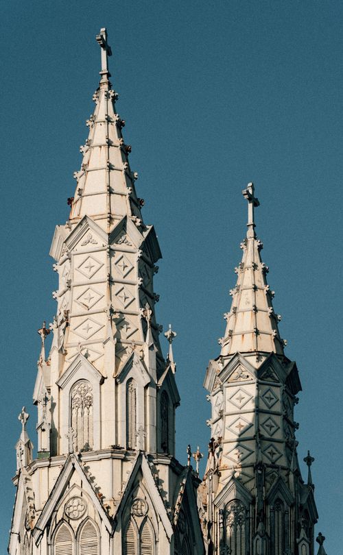 Free Imposing Gothic cathedral spires reach into a clear blue sky in El Salvador, showcasing intricate architecture. Stock Photo
