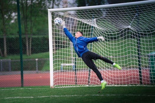Dynamic shot of a goalkeeper saving a soccer ball during a match in Rennes, France.