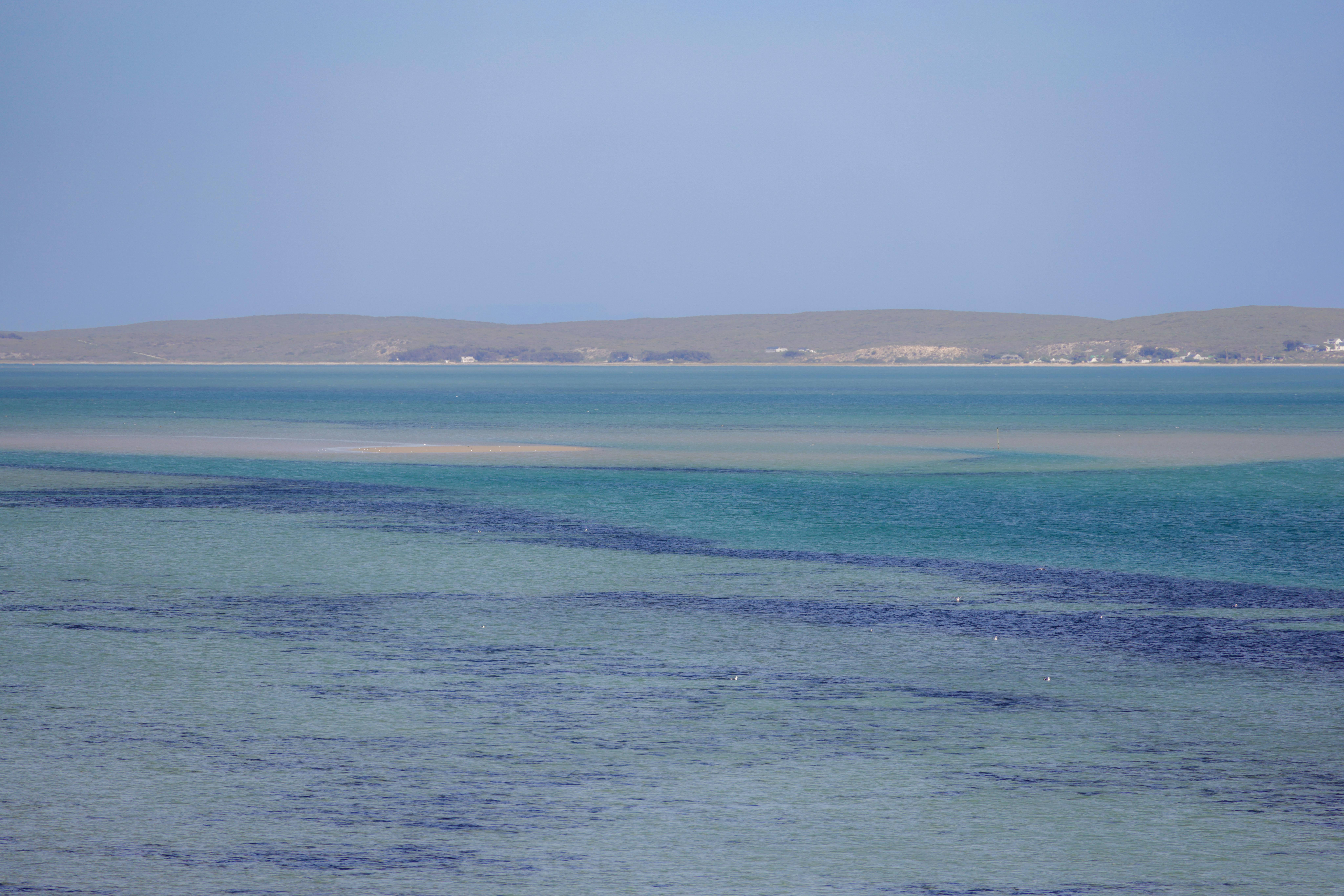 A tranquil seascape with azure waters and a serene horizon, ideal for relaxation themes.