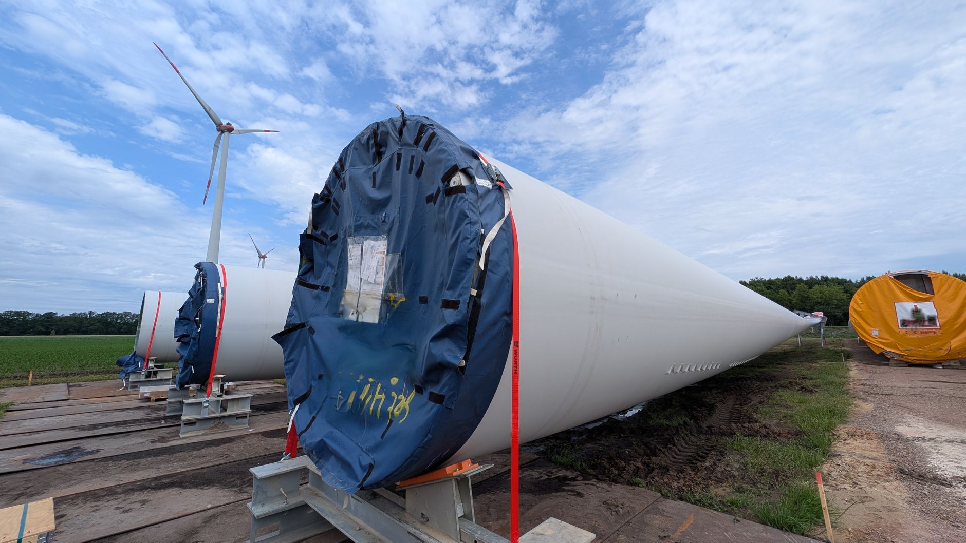 Almanya'nın enerji sektöründeki güncel iş ilanlarını ve kariyer fırsatlarını temsil eden, rüzgar türbinleri ve güneş panelleri önünde çalışan bir mühendis.