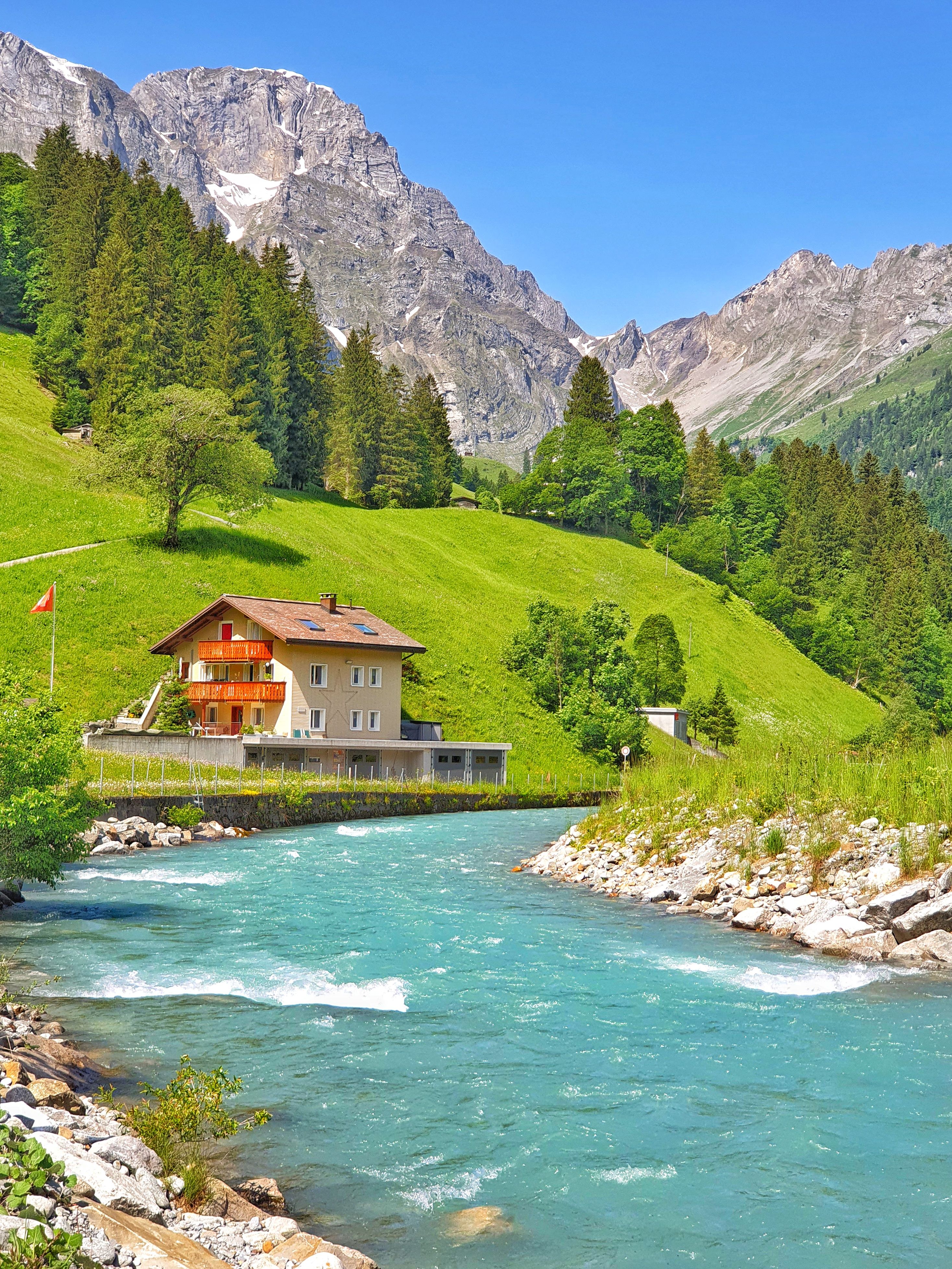 Idyllic Swiss Alpine Landscape with Chalet and River · Free Stock Photo