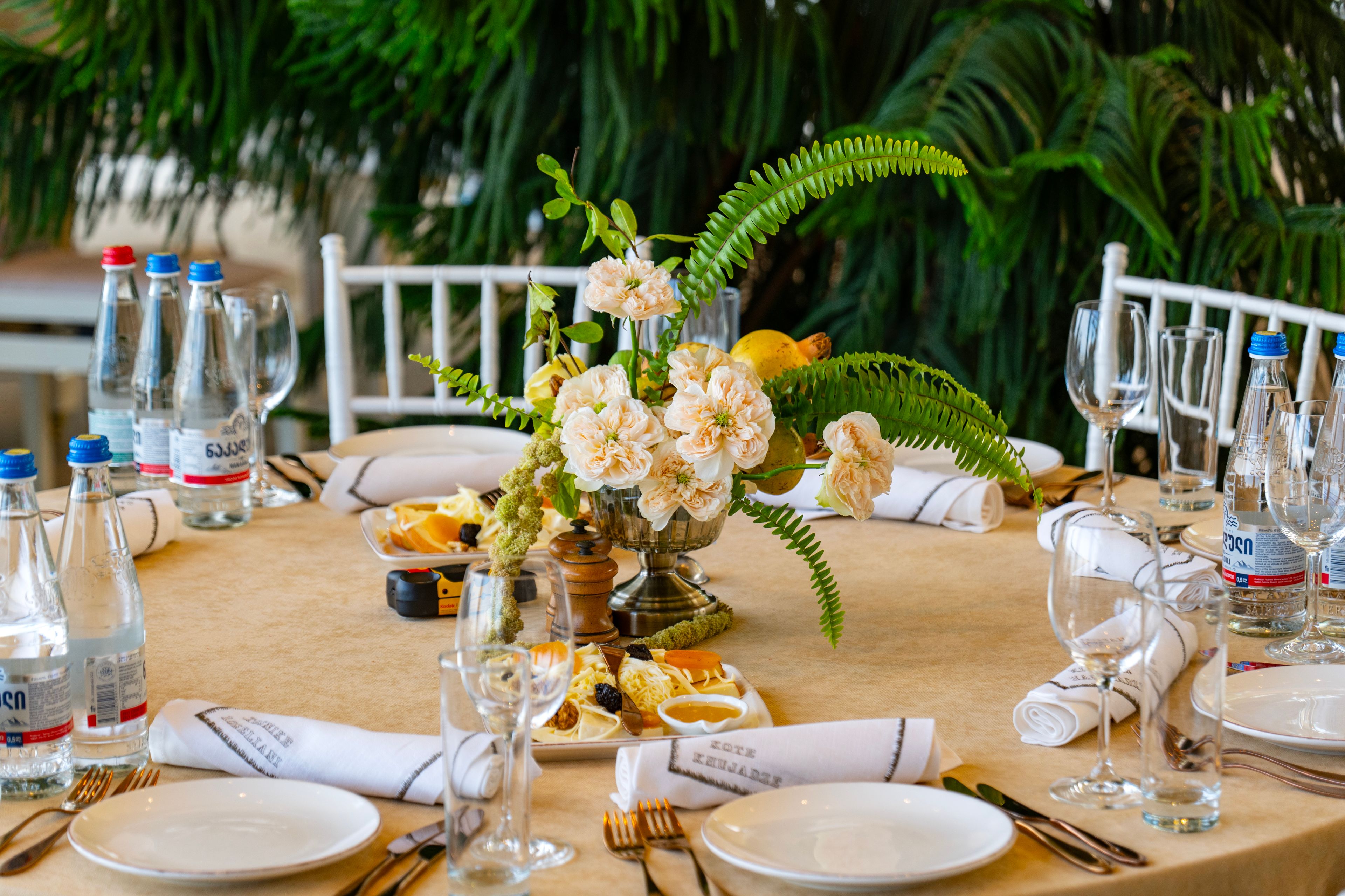 Beautifully set wedding table with elegant floral centerpiece, glassware, and cutlery in Tbilisi, Georgia.