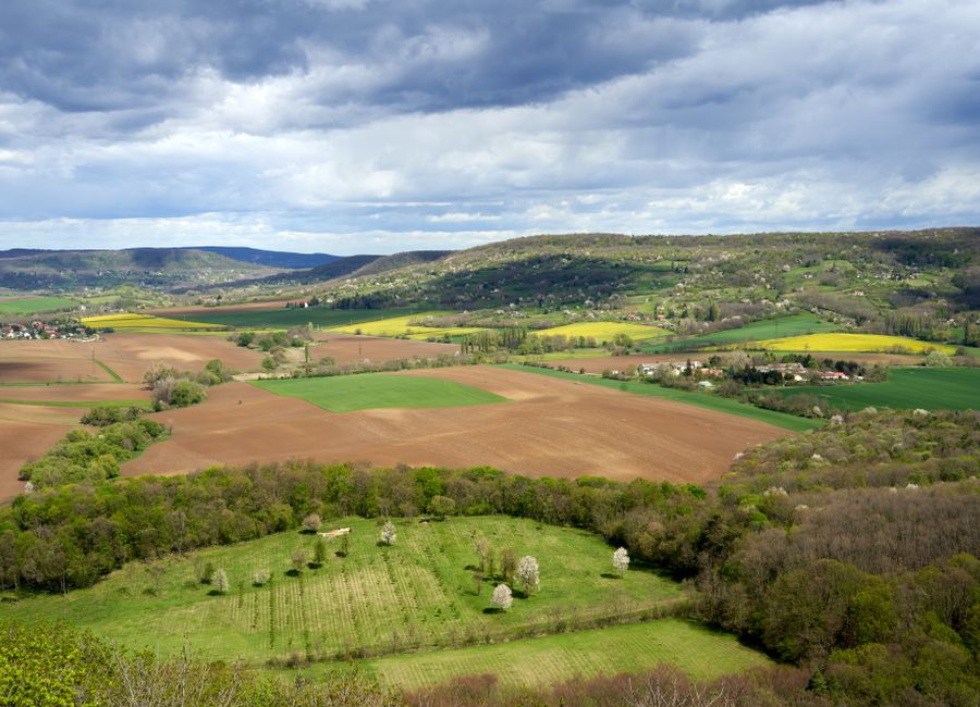 Aerial spring view of Nagygörbő's rolling fields, forests, and villages in Hungary.