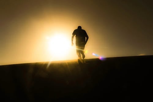 Вид сзади силуэт человека против неба во время заката