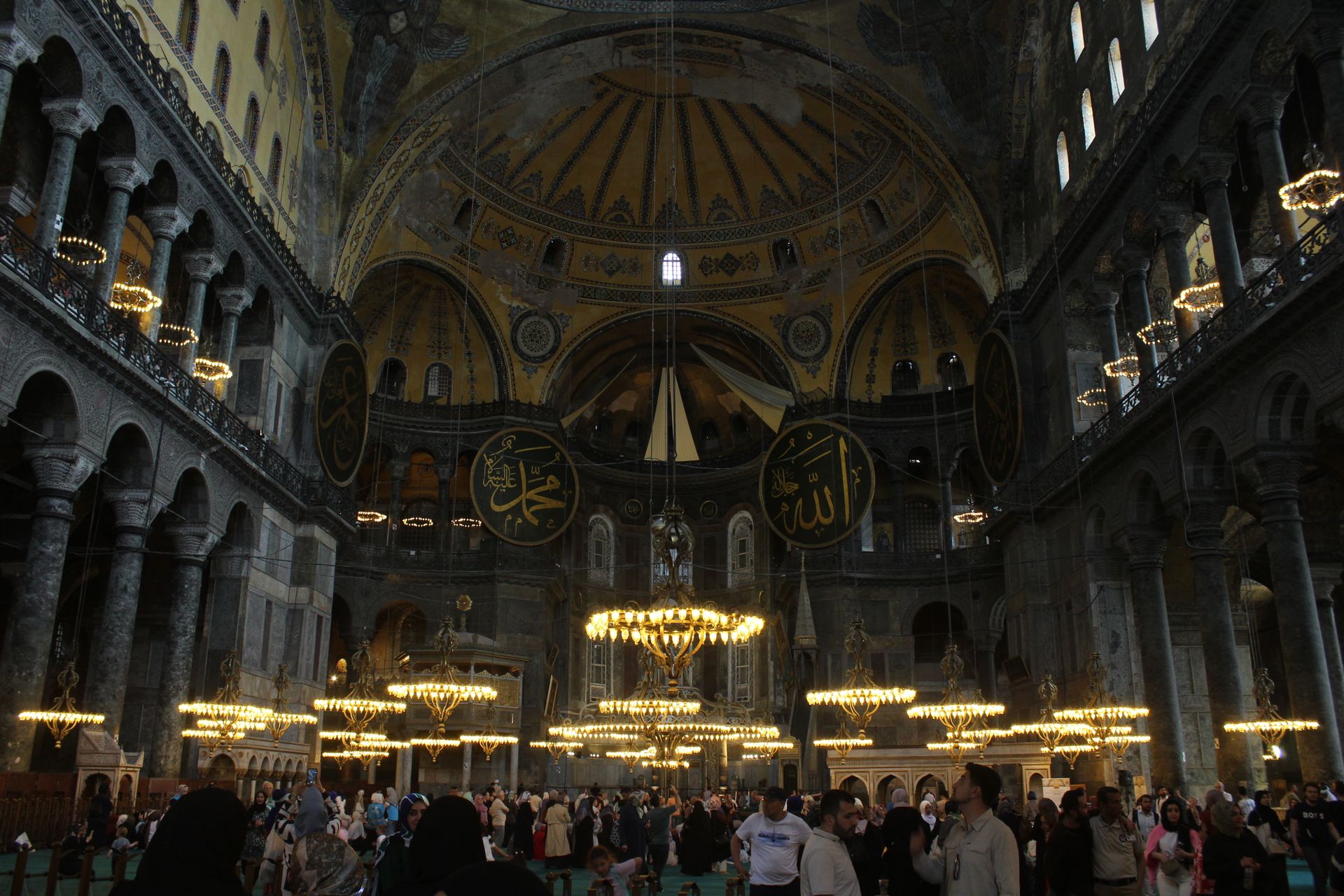 Explore the grandeur of Hagia Sophia's dome and ornate interior with visitors admiring its history.
