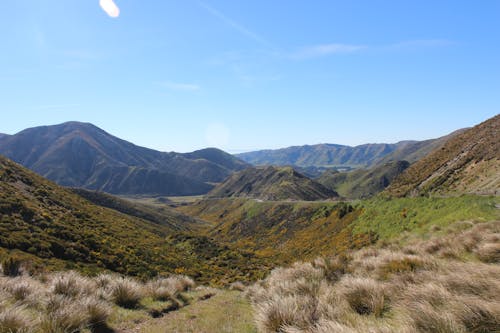 Foto d'estoc gratuïta de carretera, herba, muntanyes