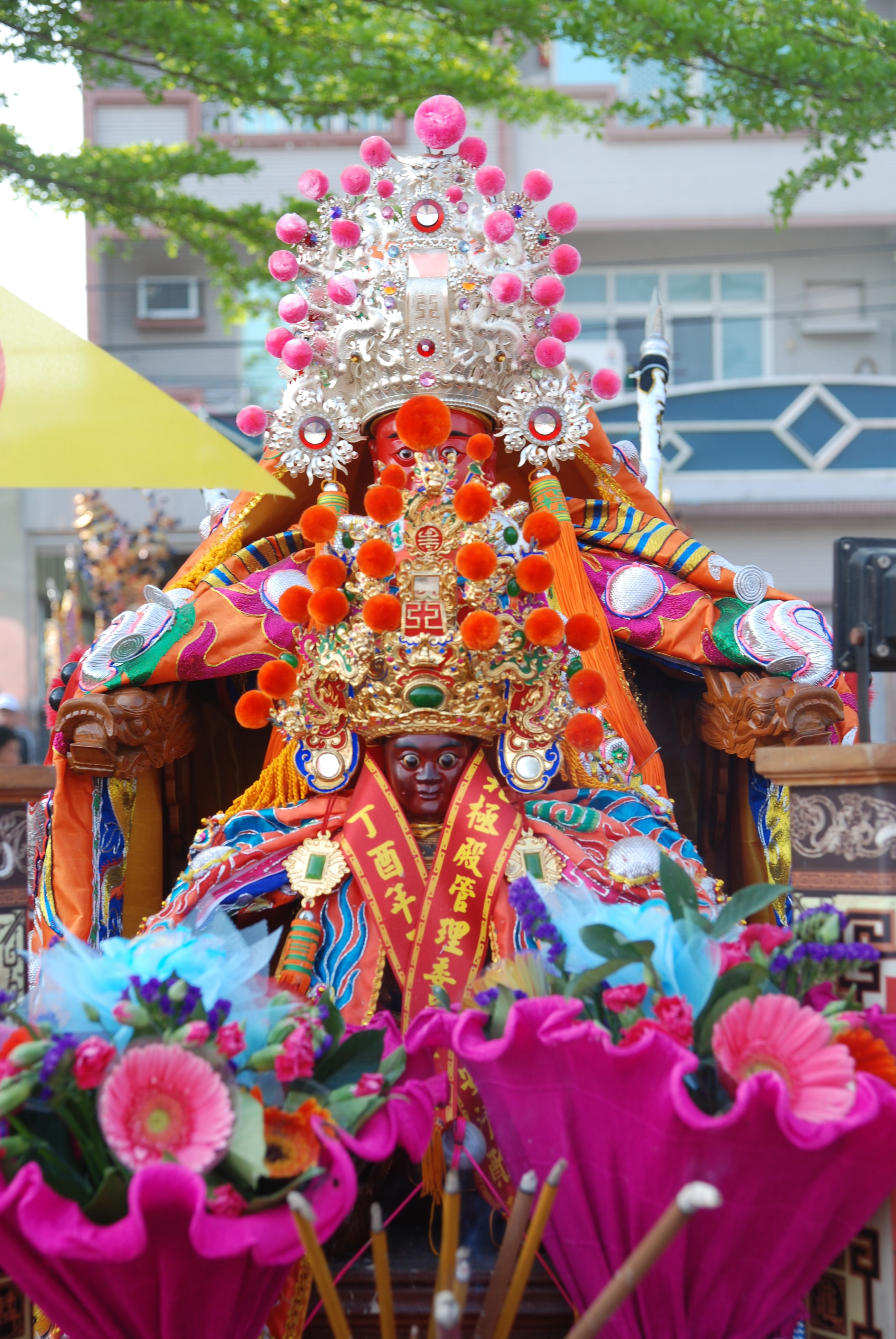 Colorful statue with ornate decorations in a vibrant outdoor festival setting.