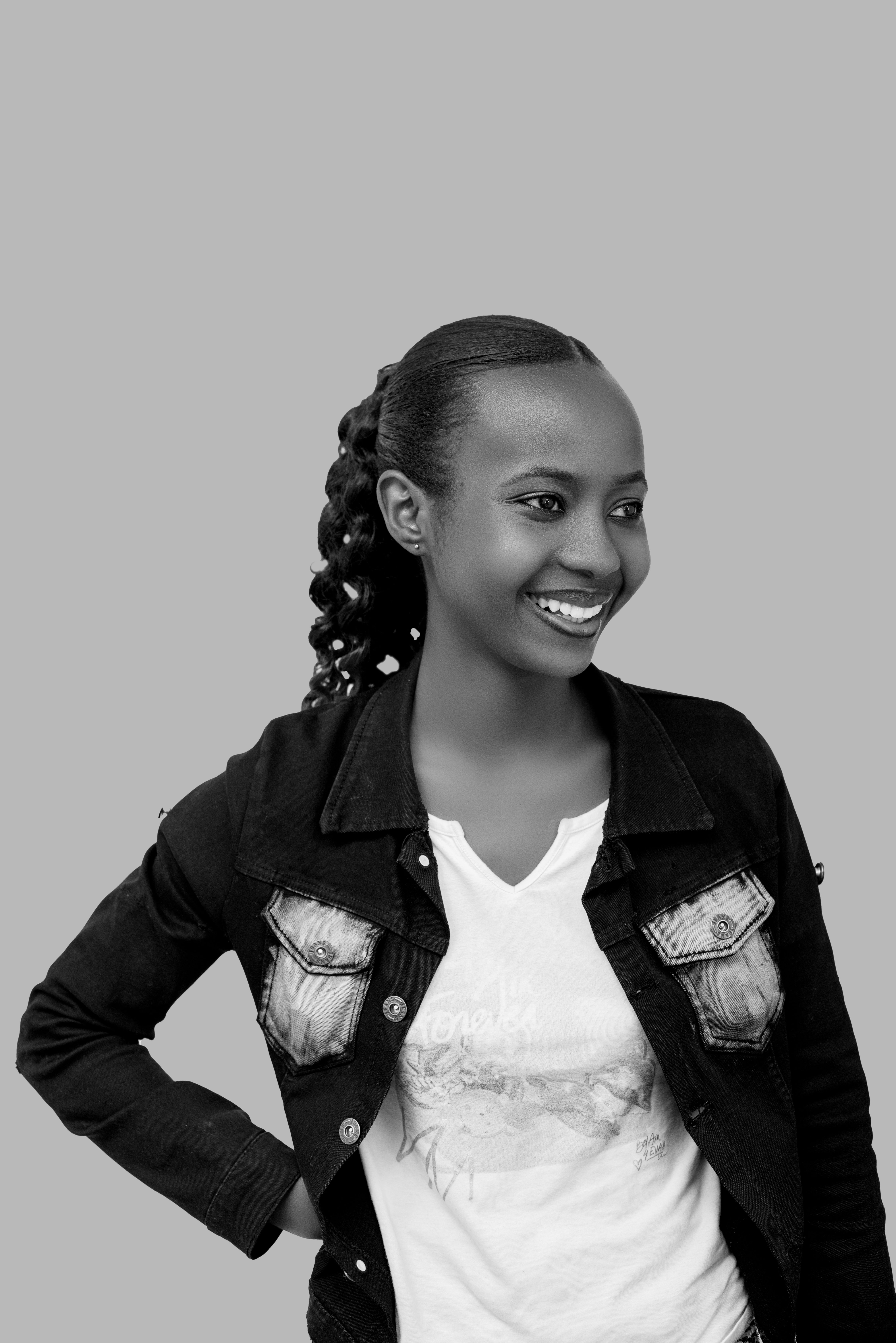 Black and white portrait of a smiling woman in casual attire with a confident pose.