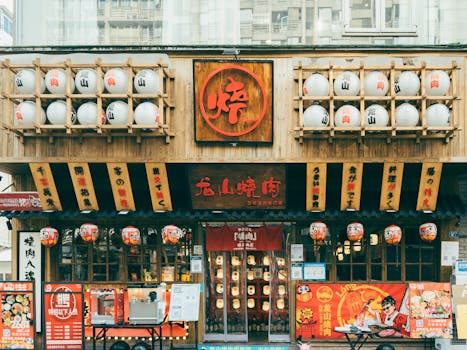 Facade of a traditional Japanese restaurant with lanterns, signage, and vibrant decorations.