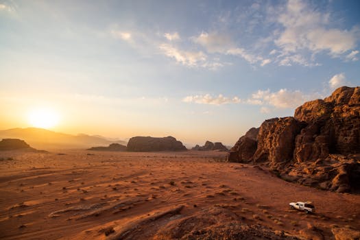 Stunning desert view of Wadi Rum in Jordan with sun setting behind sandstone formations.