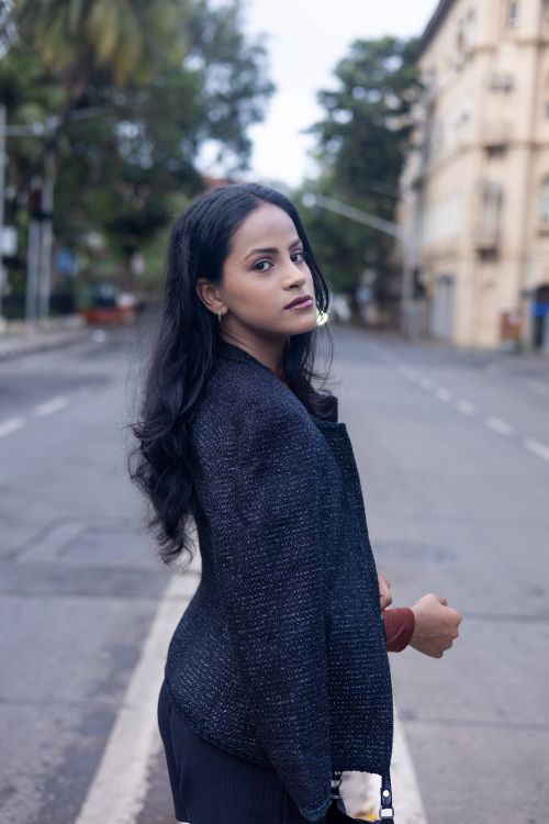 Free Confident woman in a sweater walks on a quiet city street during the day. Stock Photo