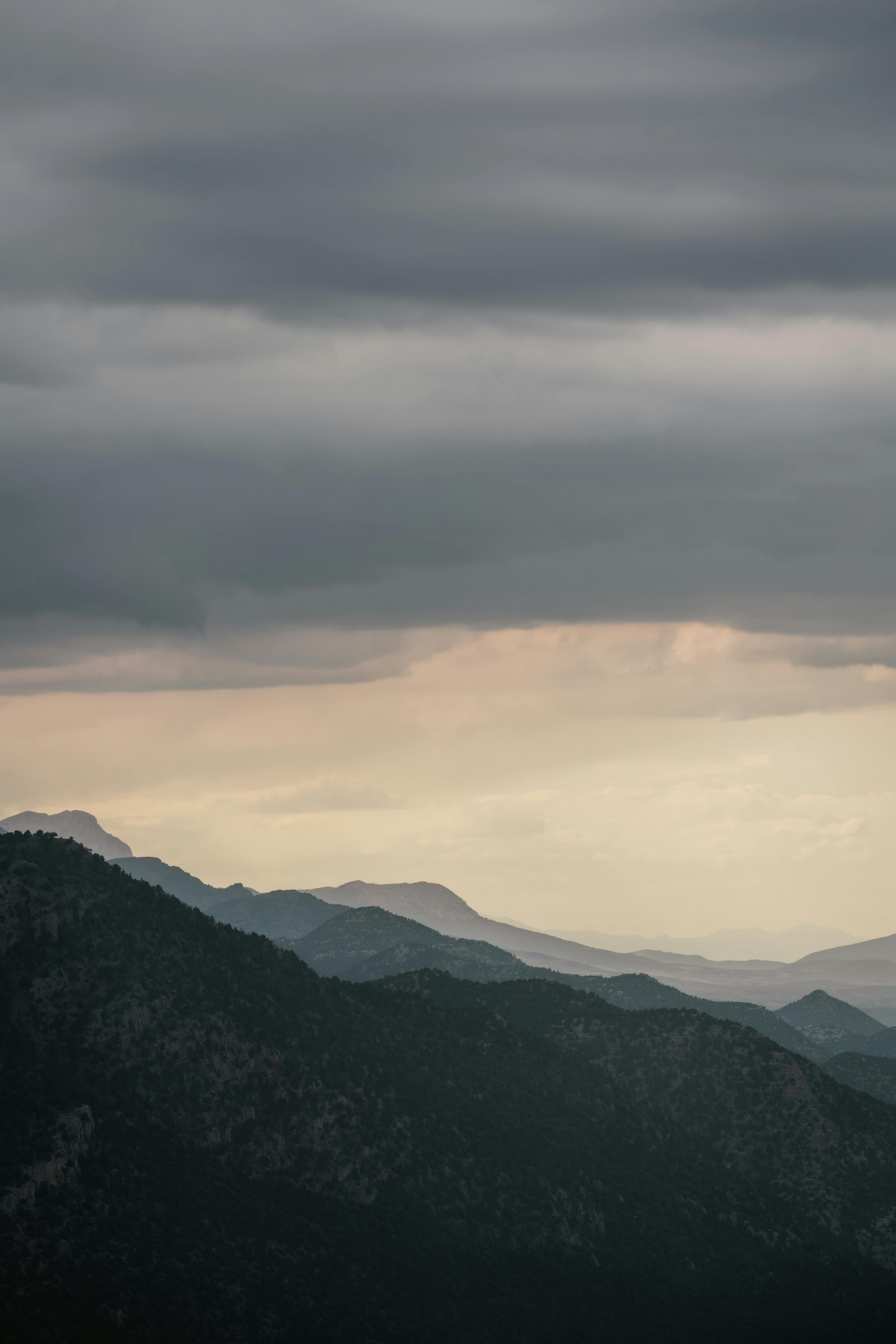 Serene twilight view of mountain silhouettes under a cloudy sky in Seydişehir, Türkiye.
