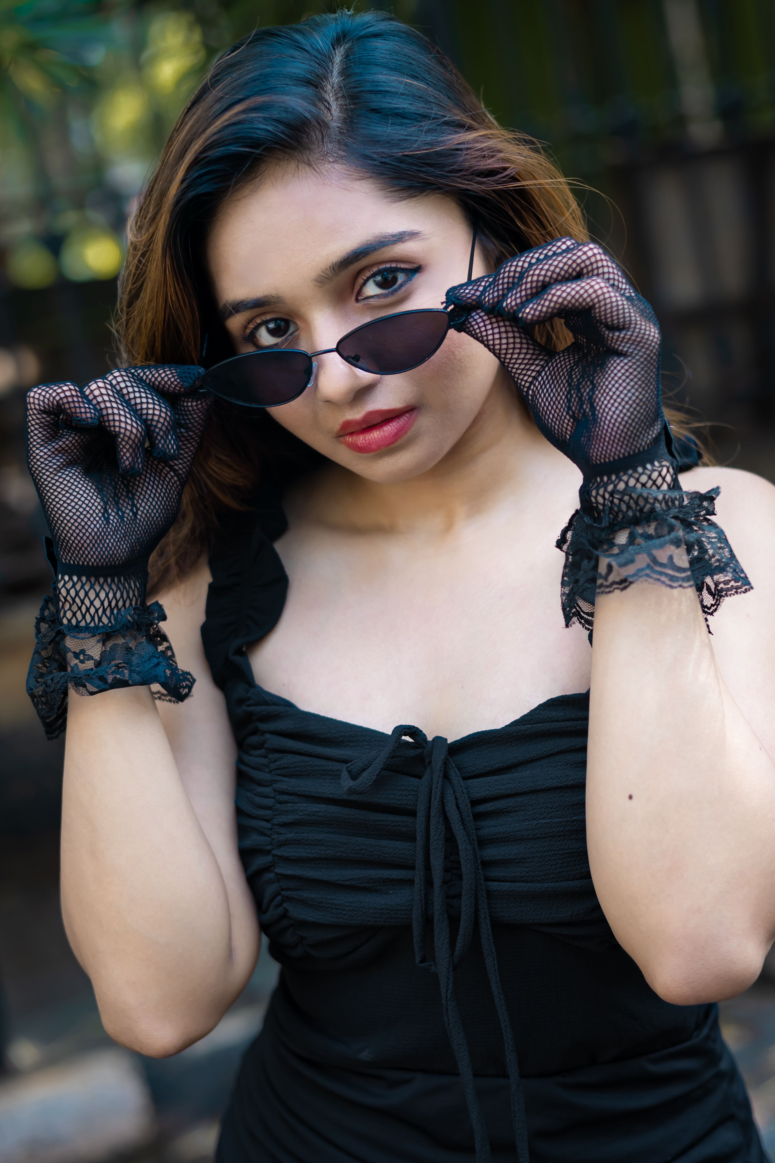 femme-l-gante-en-robe-noire-avec-des-lunettes-de-soleil-l-ext-rieur