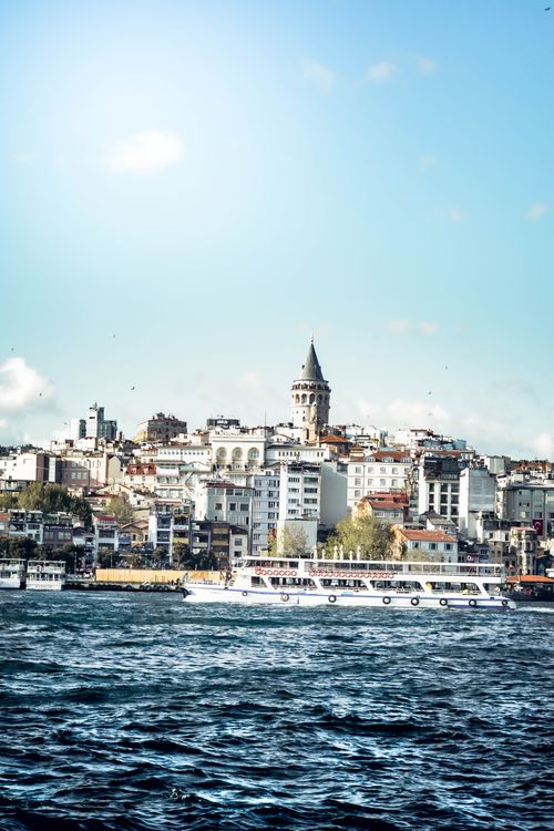Free Beautiful view of Galata Tower in Istanbul with boats cruising the Bosphorus under a bright sky. Stock Photo