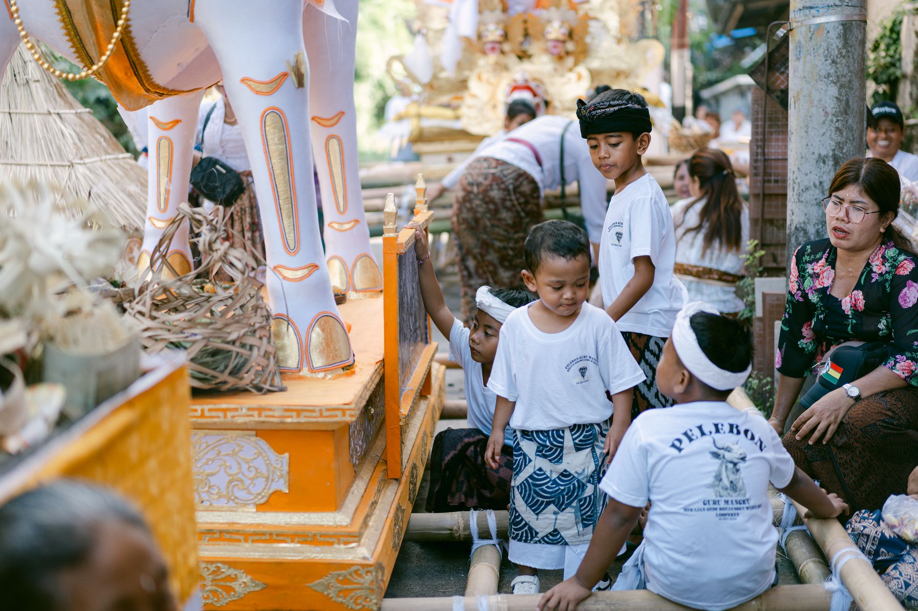 Young boys participate in a vibrant Balinese ceremony featuring cultural attire and traditional decorations.