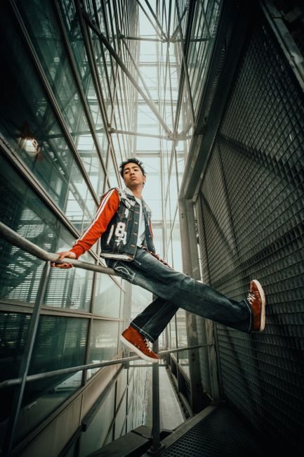 Stylish urban portrait of a young man in a modern architectural setting.