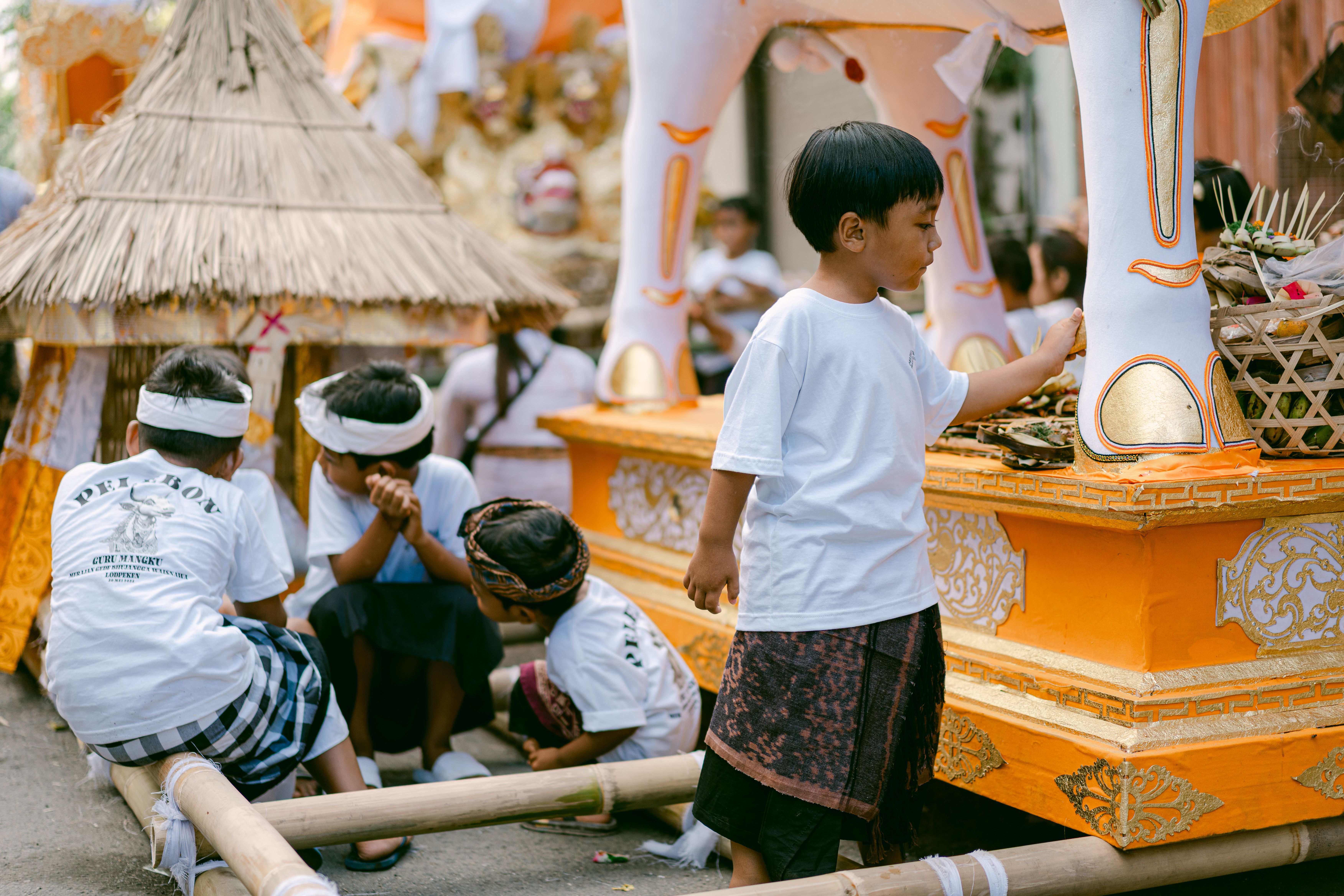 Children engaged in activities during a vibrant cultural festival with traditional attire and decorations.