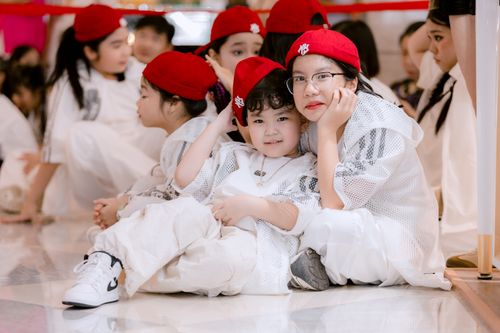 Free Group of children in red berets seated indoors, showcasing friendship and unity. Stock Photo