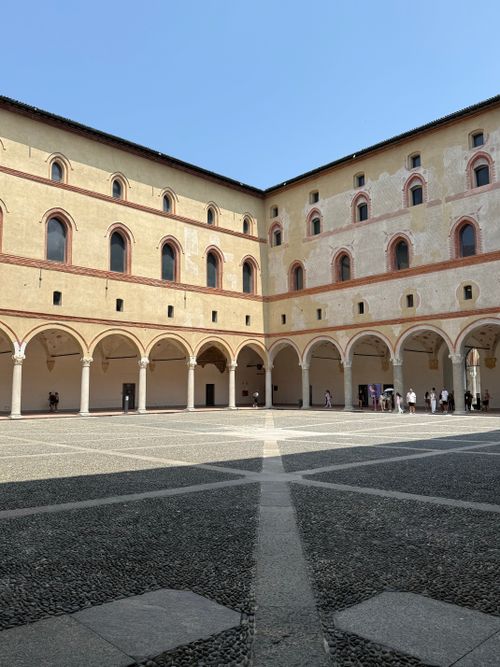 Free Scenic view of a medieval courtyard with arches and stone pavement in Italy. Stock Photo
