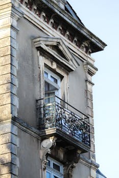 Close-up of a historic building's ornate balcony in Hendaya, France. Captured in soft daylight.