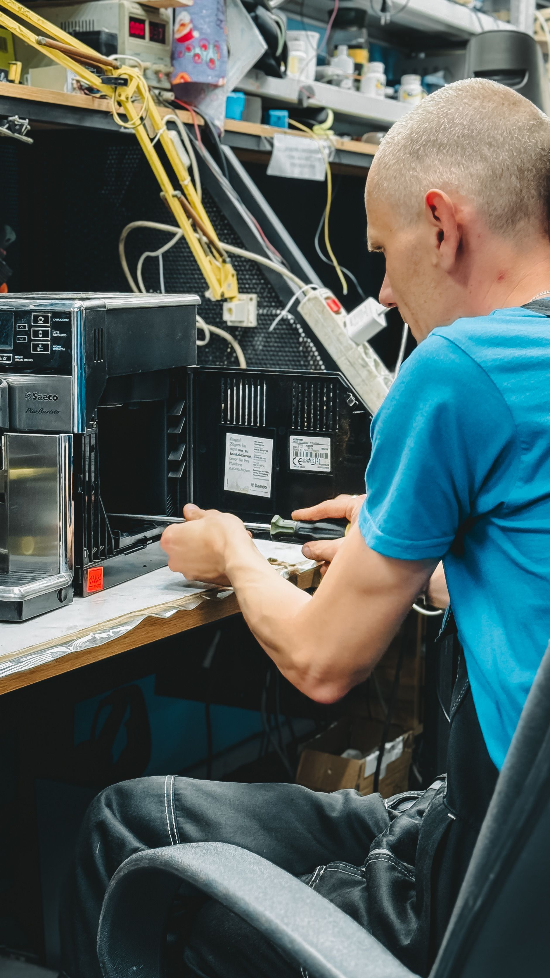Serious ethnic field engineer examining hardware and working on laptop ...