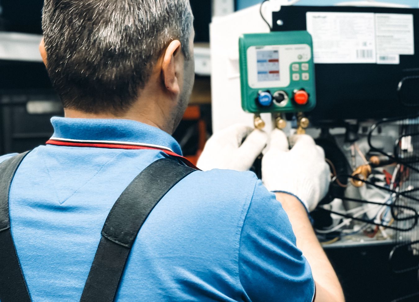 Técnico realizando conserto em geladeira em ambiente de assistência técnica