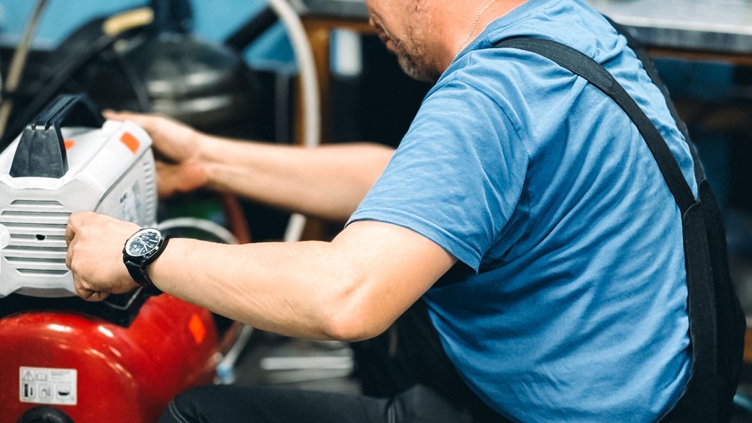 A repairman working on equipment in a workshop