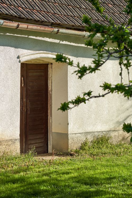 Free Charming rustic door of a traditional farmhouse in Türje, Hungary, surrounded by greenery. Stock Photo