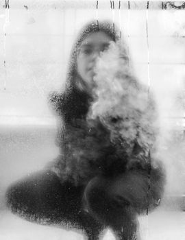 Blurred reflection of a person in a foggy window, creating a mysterious urban vibe.