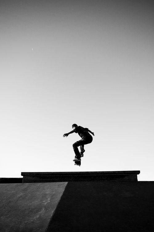 Free Silhouette of a skateboarder mid-jump in Buenos Aires, captured in black and white for a dramatic urban feel. Stock Photo