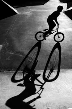 A captivating black and white image of a BMX rider's silhouette captured in an urban setting.