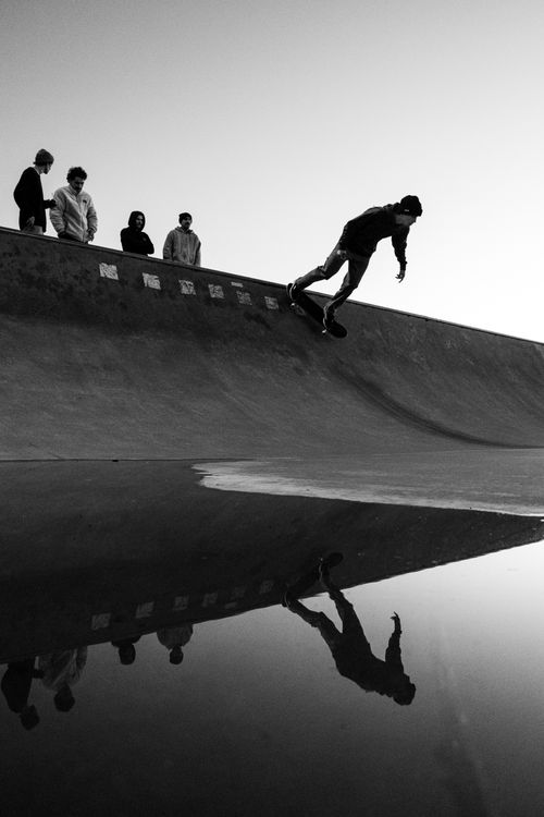 Free Silhouette of a skateboarder performing a stunt with reflection in Buenos Aires skate park. Stock Photo