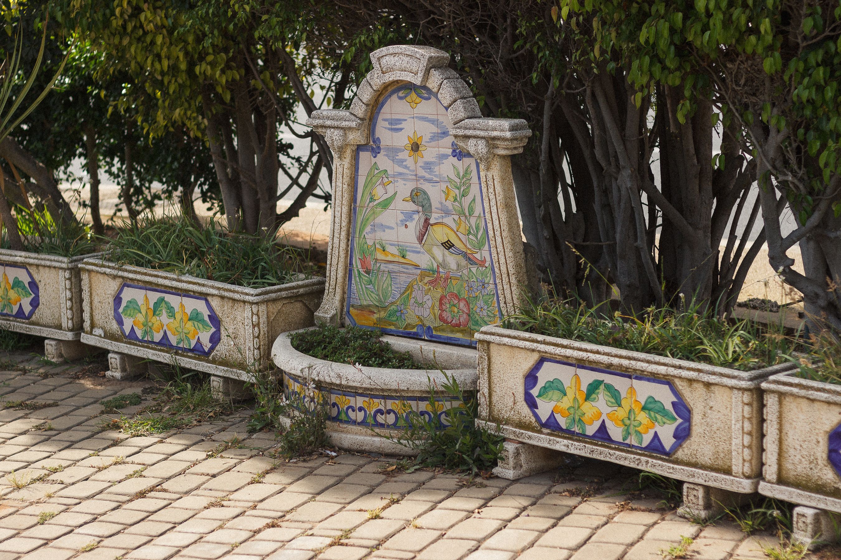 Arco de pedra com fonte em jardim