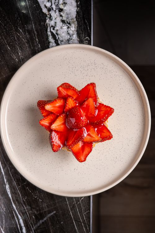 Free A deliciously arranged strawberry tart on a ceramic plate, perfect for dessert visuals. Stock Photo