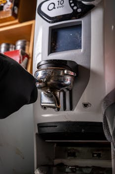 Close-up of barista using Q10 Evo coffee machine to make espresso, showcasing professional coffee preparation.