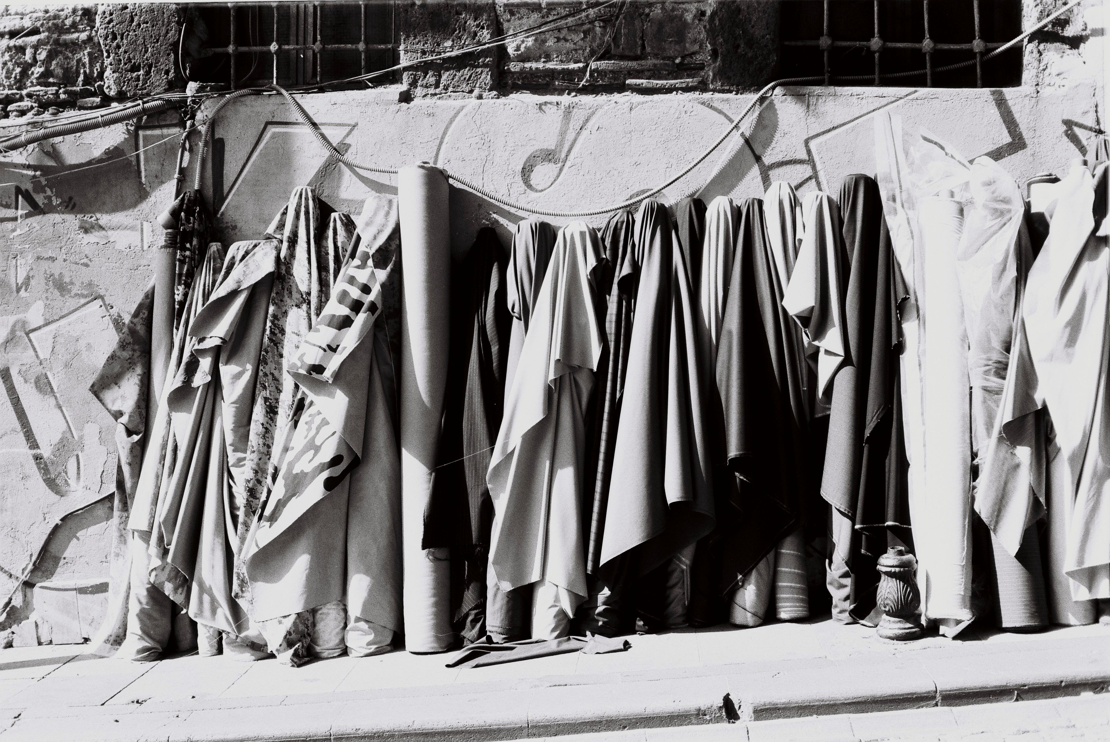 Gratuit Prise de vue monochrome de rouleaux de tissu contre un mur texturé à Istanbul, en Turquie. Photos