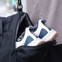 White trainers packed in an open black gym bag
