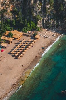 Aerial perspective of Kabak Beach, showcasing sandy shores, turquoise waters, and sun loungers in a serene setting.
