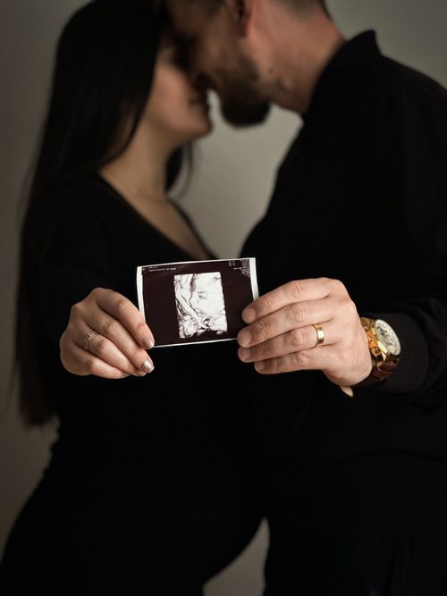 Free A couple lovingly holds an ultrasound image, announcing their joyful pregnancy. Stock Photo
