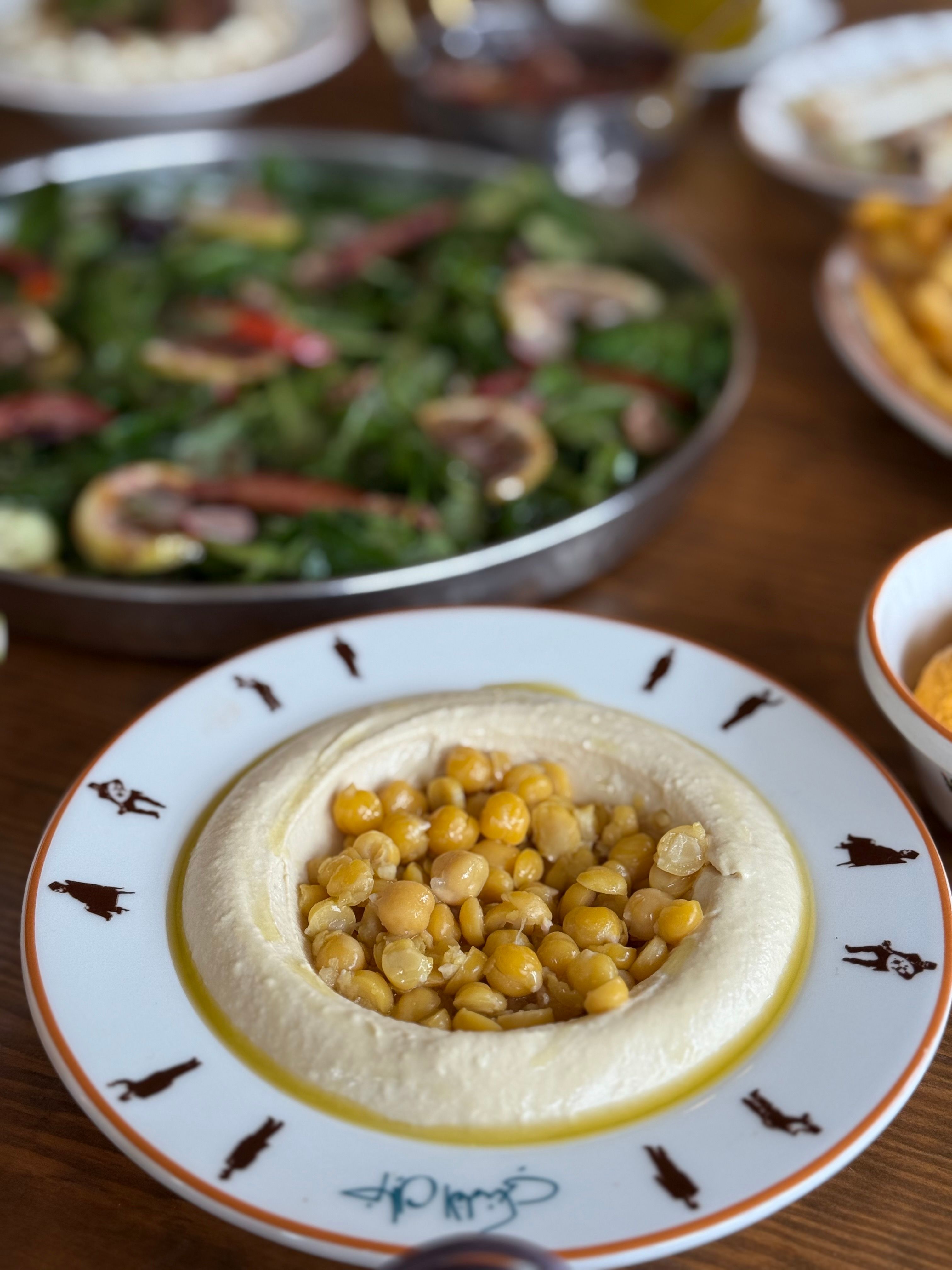 Chickpea-topped hummus served with fresh salad, perfect for a healthy meal.