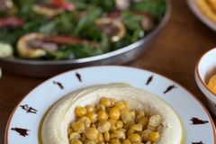Chickpea-topped hummus served with fresh salad, perfect for a healthy meal.