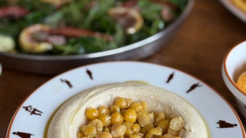 Chickpea-topped hummus served with fresh salad, perfect for a healthy meal.