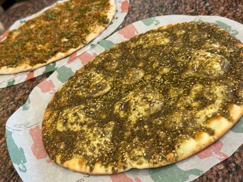 Free Close-up of zaatar and lahmajoun on paper, showcasing vibrant Middle Eastern flavors. Stock Photo