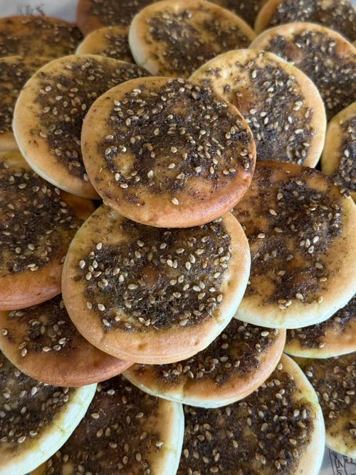 Free Savor the taste of freshly baked manakish topped with flavorful za'atar seasoning. Stock Photo