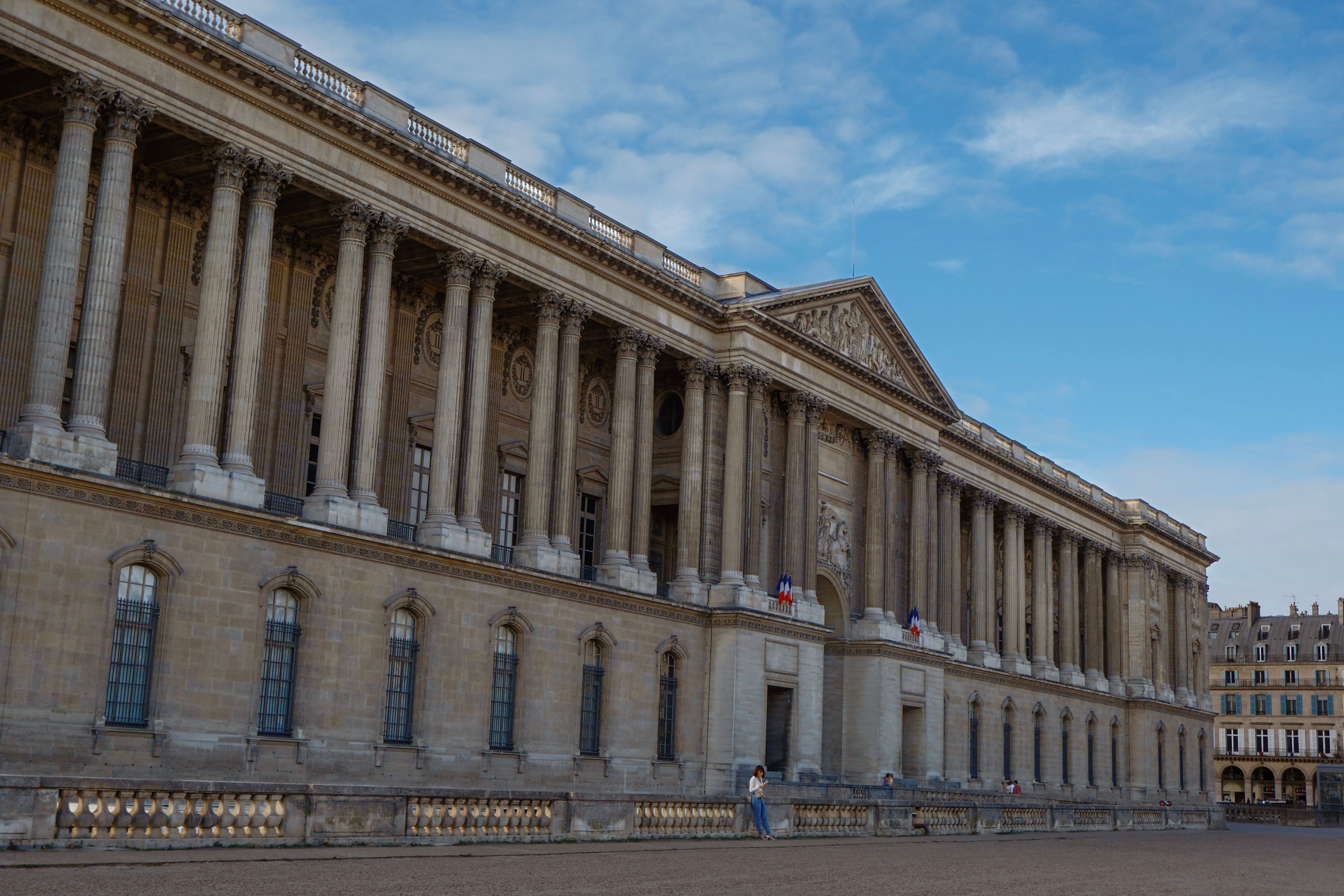 The grand exterior of the Louvre Palace in Paris, showcasing classical French architecture.