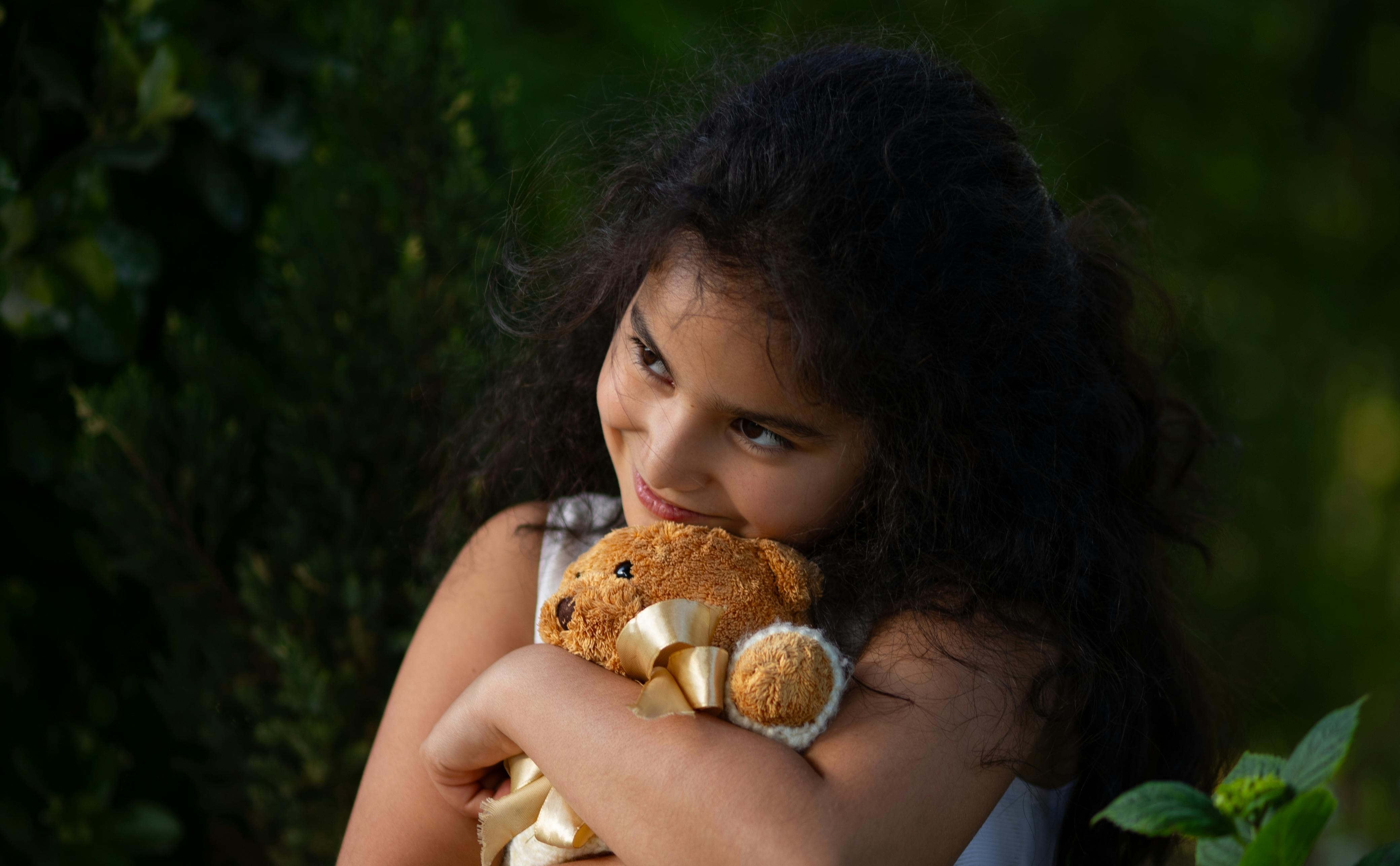 Ребенок обнимает плюшевого мишку