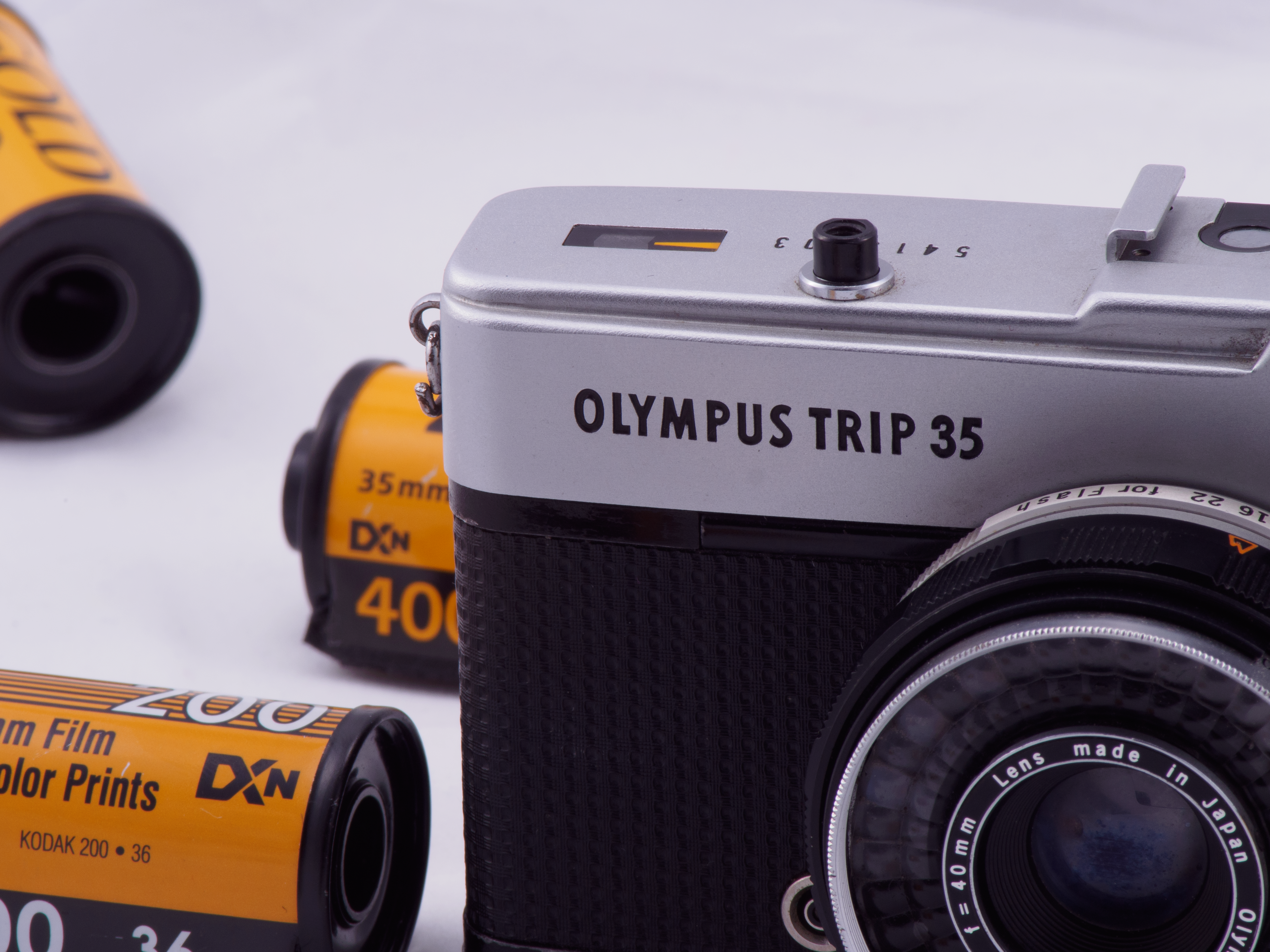 Close-up of a vintage Olympus Trip 35 camera with film rolls.