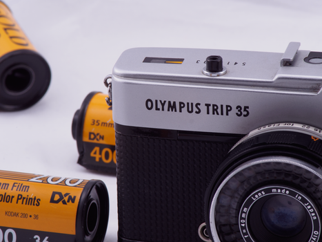 Close-up of a vintage Olympus Trip 35 camera with film rolls.